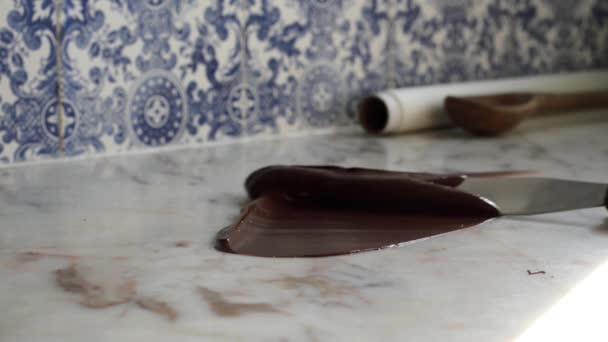 artesanato culinário caseiro têmpera suave confeitaria chocolate escuro no balcão de mármore com azulejos azuis e brancos no fundo
. - Filmagem, Vídeo