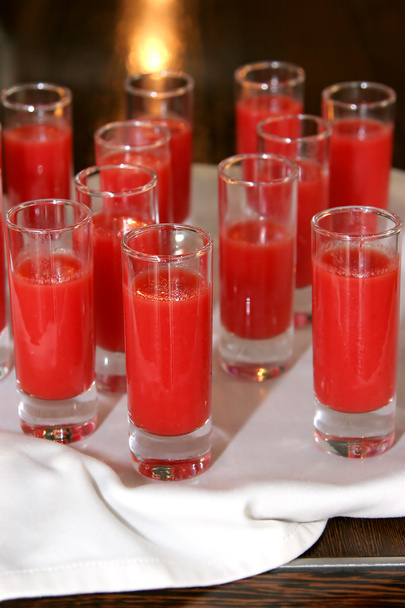 vários copos de tiro com bebidas vermelhas
 - Foto, Imagem