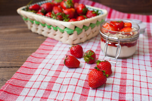 Fresh strawberries on the tablecloth and in the basket - Fotoğraf, Görsel