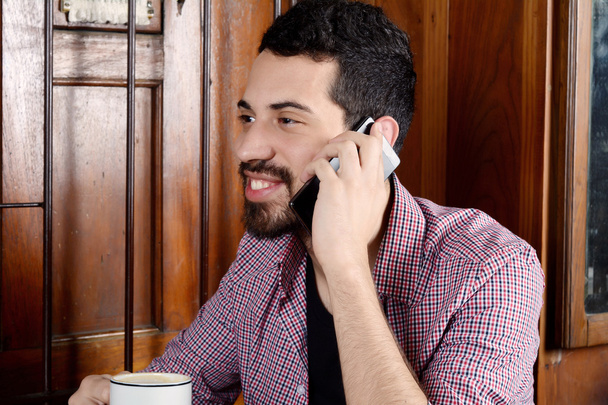 Man talking on phone and drinking coffee. - Foto, Imagen