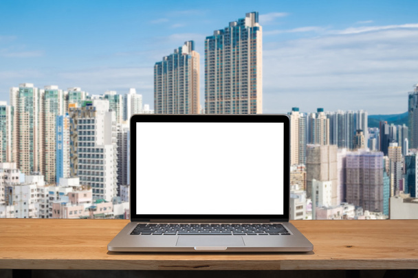 Laptop mit leerem Bildschirm auf dem Tisch. hong kong Gebäude Hintergrund - Foto, Bild