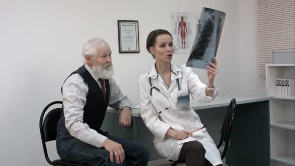 Doctor explaining x-ray results to senior patient. - Video, Çekim