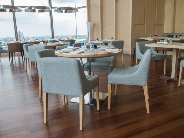 Современный ресторан отеля с деревянной мебелью и видом на реку
 - Фото, изображение