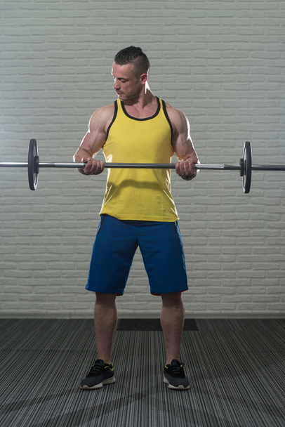 Biceps Exercise With Barbell On White Bricks Background - Fotografie, Obrázek