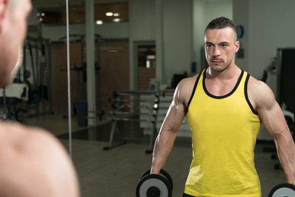 Young Man With Dumbbells Exercising Biceps - Valokuva, kuva