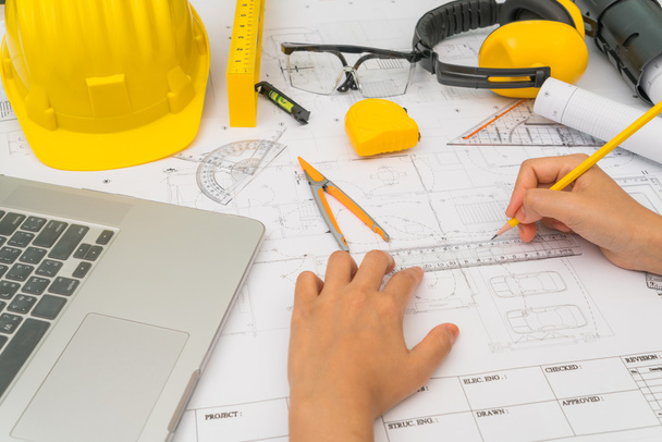 Hand over Construction plans with yellow helmet and drawing tool - Foto, immagini