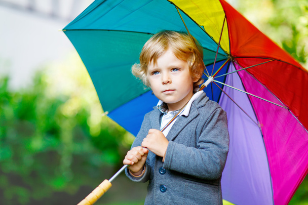 Little cute toddler boy with colorful umbrella and boots, outdoo - Photo, Image
