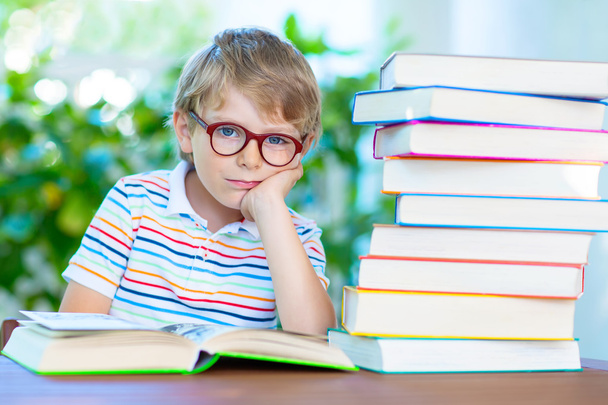 frustrado pequeño colegial con gafas y libros
 - Foto, imagen