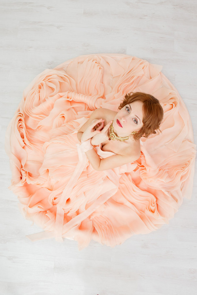 Portrait of a beautiful girl in a beige peach dress - Foto, imagen