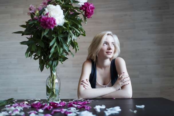 Portrait of beautiful girl blonde at table - Фото, изображение