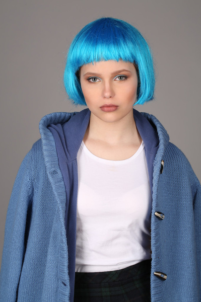 Girl with blue hair and coat. Close up. Gray background - Φωτογραφία, εικόνα