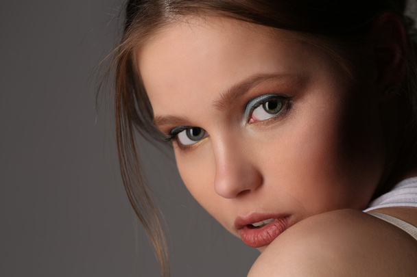 Girl with makeup and big eyes. Close up. Gray background - Foto, Imagen