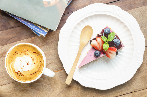 Blue berry cheese cake and coffee latte on wooden desk - Фото, зображення