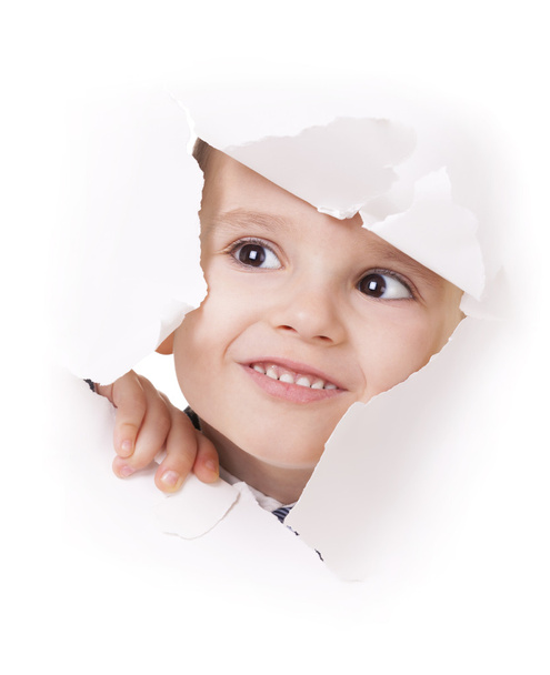 Curious kid looks through a hole in white paper - Foto, immagini