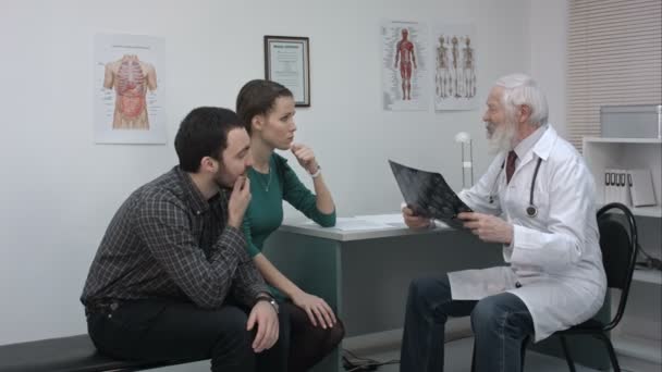 Healthcare and medical concept. Doctor with patients looking at x-ray. - Кадри, відео
