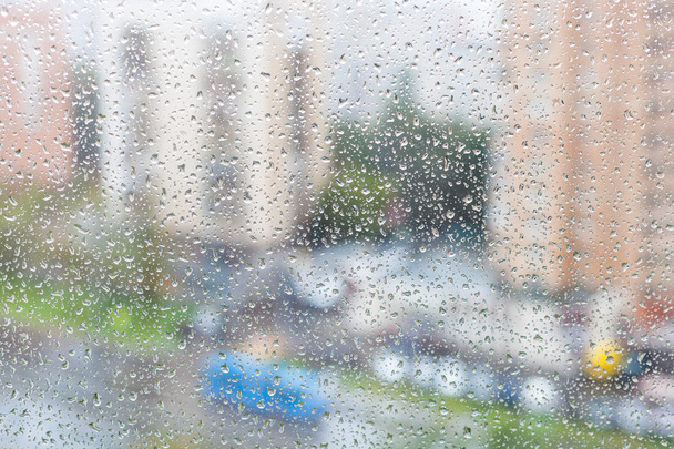 вид на краплі дощу на віконній панелі міського будинку
 - Фото, зображення