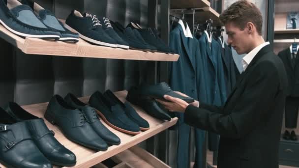 Mężczyzna kupuje klasyczne ubrania i buty - Materiał filmowy, wideo