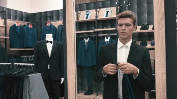 El hombre en el probador, mirando en el espejo corrige la corbata
 - Metraje, vídeo