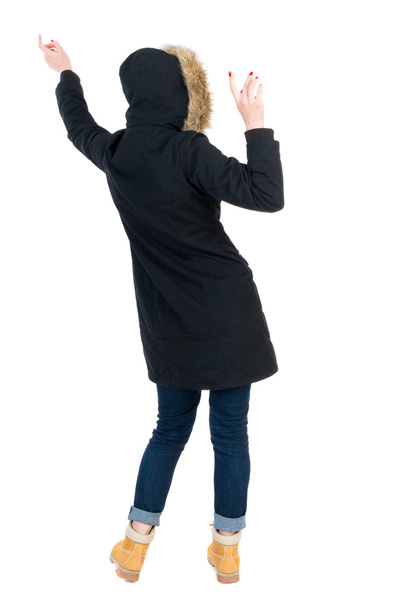 Back view woman in winter jacket  Balances waving his arms. - Fotografie, Obrázek