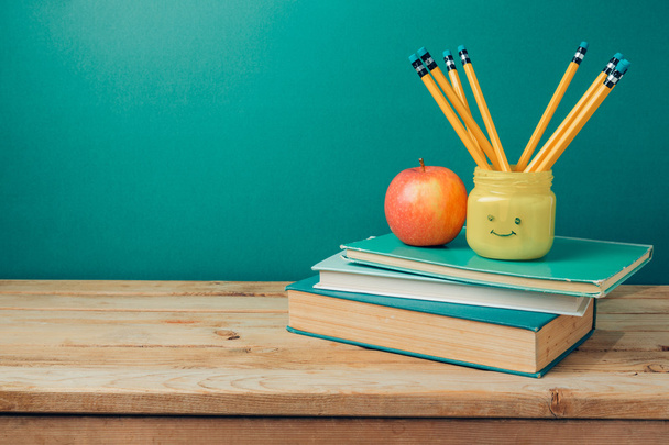 boeken, potloden in emoji kruik en appel - Foto, afbeelding