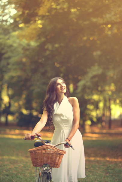 Kaunis nainen ratsastus bicylce puistossa ja nauttia kauniista su
 - Valokuva, kuva