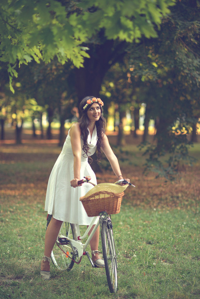 Beautiful woman riding bicylce in park and enjoying beautiful su - Valokuva, kuva