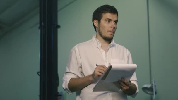 El hombre está anotando las notas en la oficina
 - Metraje, vídeo