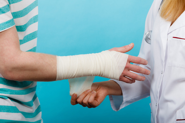 Doctor bandaging sprained wrist. - Foto, Imagen