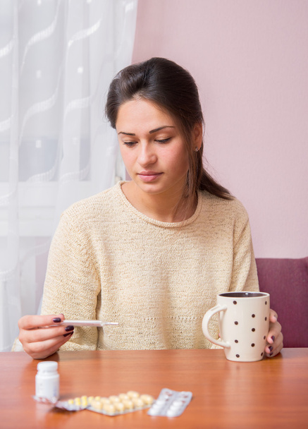 Girl with a cup of tea checks temperature - Φωτογραφία, εικόνα