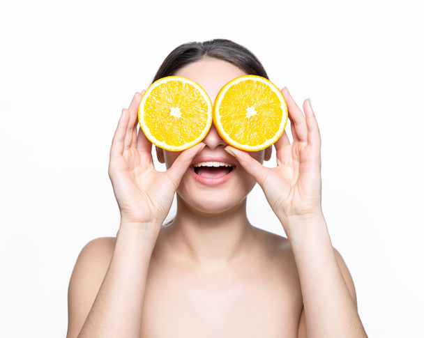 pretty girl holding oranges in front of eyes - Foto, immagini
