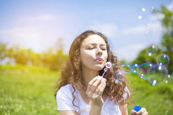Young woman blowing bubbles  - Foto, afbeelding