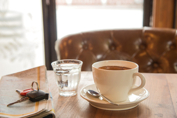 White coffee cup , blurred newspaper, car key  and glass water o - Foto, Bild