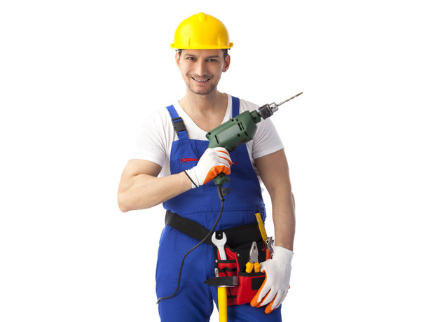Smiling handyman holding drill machine - Фото, зображення