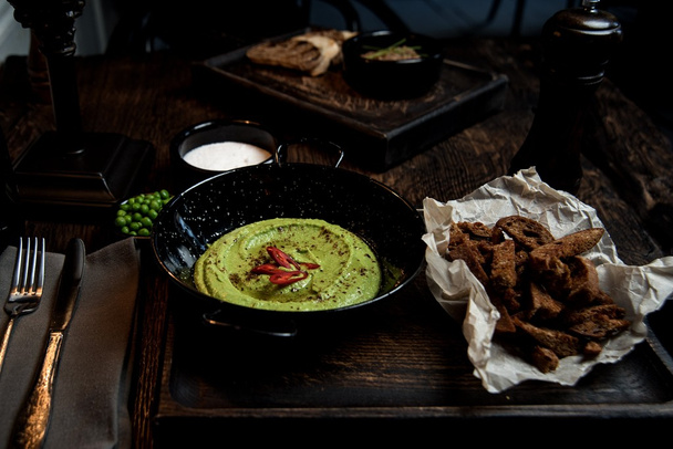 hummus in a bowl on a wooden table - Φωτογραφία, εικόνα