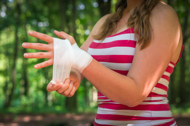 Kadın bandaj elinde yaralanma sonra uygulamak. - Fotoğraf, Görsel