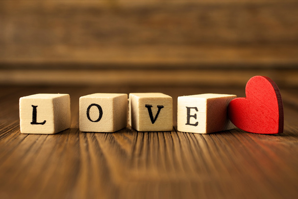 Love. Love message written in wooden blocks. Red heart.  - Фото, зображення