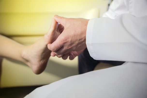 les mains du médecin examinent le pied d'un patient
 - Photo, image