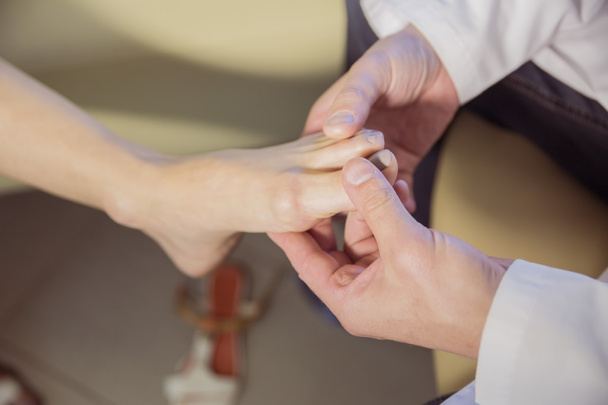 las manos del médico examinan el pie de un paciente
 - Foto, Imagen