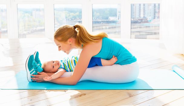 sporten moeder houdt zich bezig met fitness en yoga met baby thuis  - Foto, afbeelding