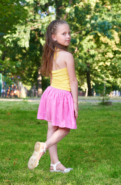 boldog gyermek lány öltözött pózol, gyermekkor fogalma, a nyári szezonban a Városliget alkalmi ruha - Fotó, kép