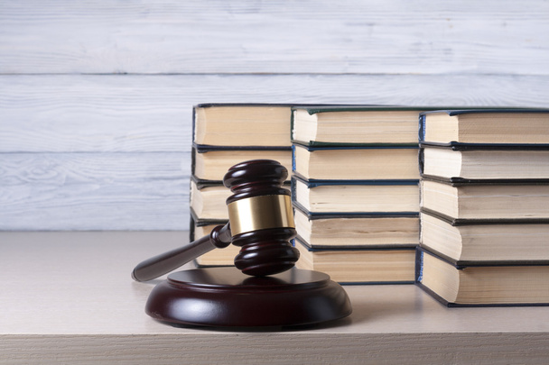 Concepto de ley - Libro con jueces de madera martillo en la mesa en una sala de tribunal u oficina de aplicación
. - Foto, imagen