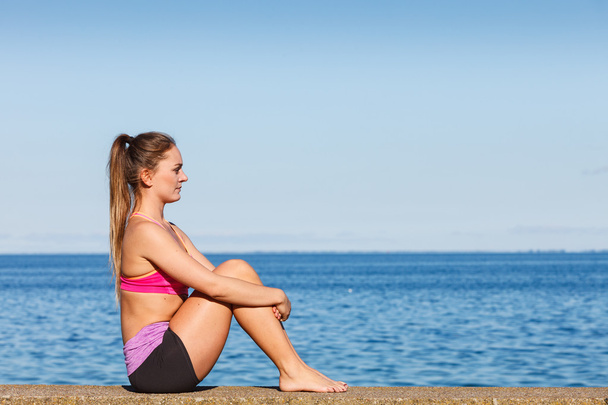 Mulher fazendo exercícios esportivos ao ar livre à beira-mar
 - Foto, Imagem