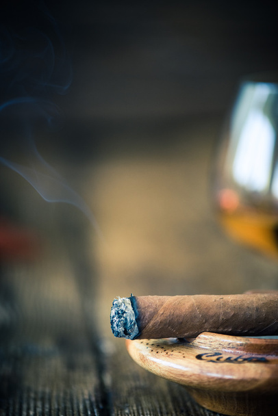 smoking cigar close up view, in wooden ashtray - 写真・画像
