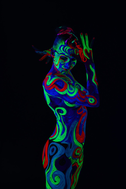 Girl with body art glowing in ultraviolet light - Фото, изображение