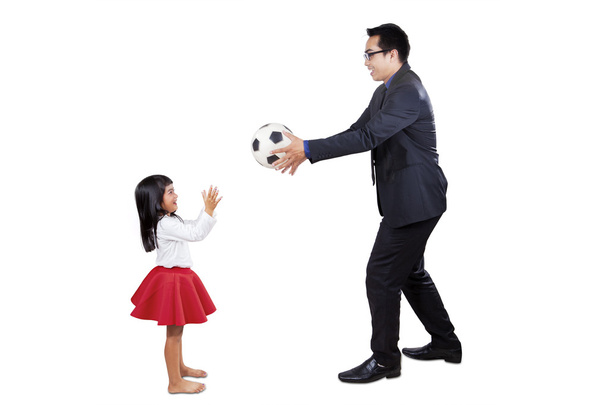 Uomo d'affari che gioca a palla con sua figlia
 - Foto, immagini