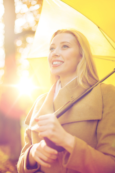 woman with yellow umbrella in the autumn park - Zdjęcie, obraz