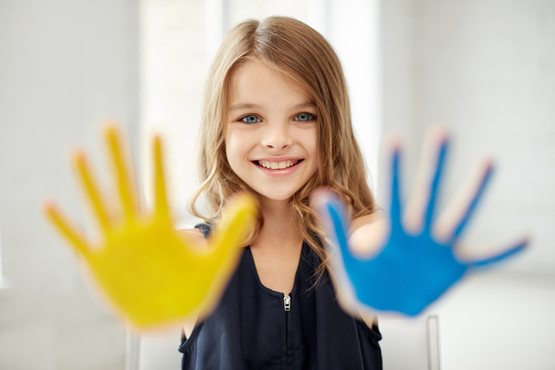 happy girl showing painted hand palms at home - Фото, изображение