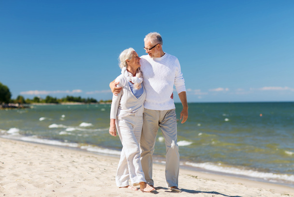 happy senior couple hugging on summer beach - Photo, image