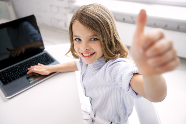 sorridente ragazza con computer portatile mostrando pollici a casa
 - Foto, immagini