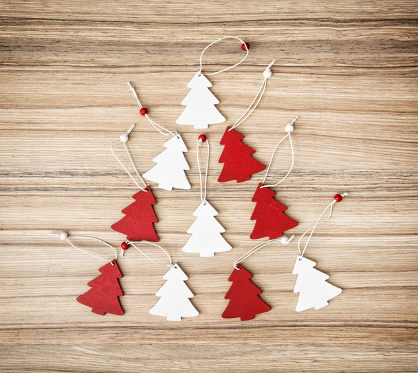 Ahşap doku üzerinde kırmızı ve beyaz dekoratif Noel ağaçları - Fotoğraf, Görsel
